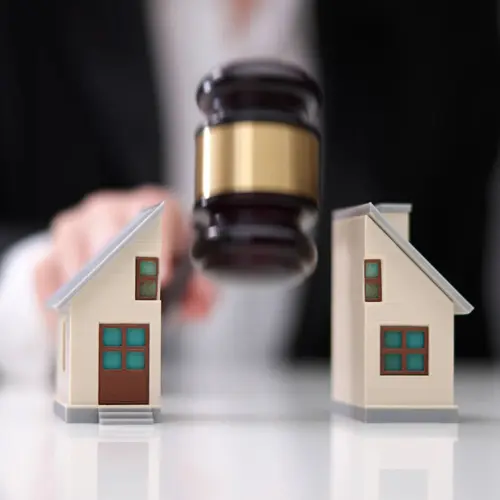 An image of a house being divided by  a gavel. 